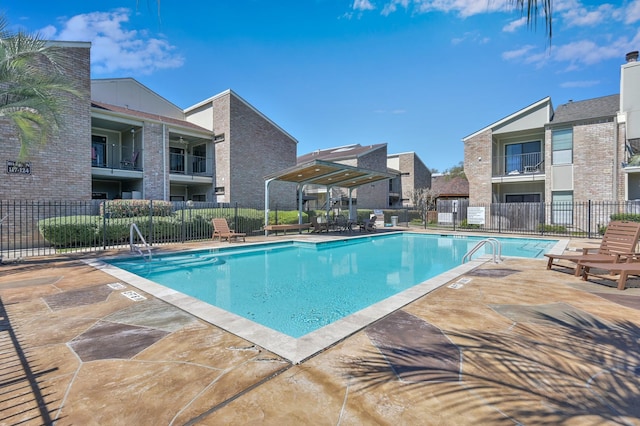 pool with a patio and fence