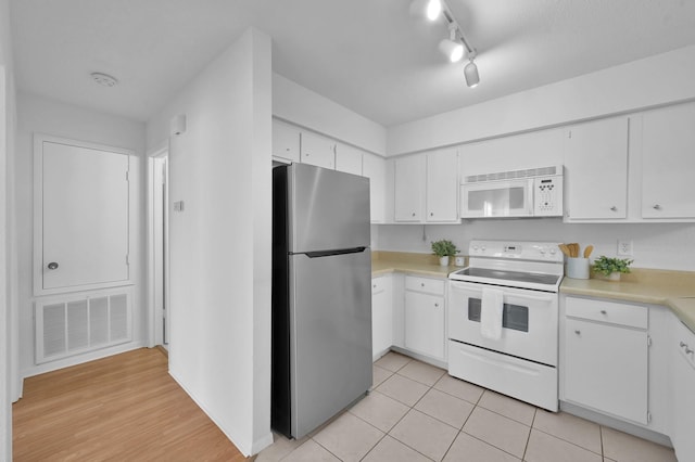 kitchen featuring visible vents, light countertops, light tile patterned floors, white cabinets, and white appliances