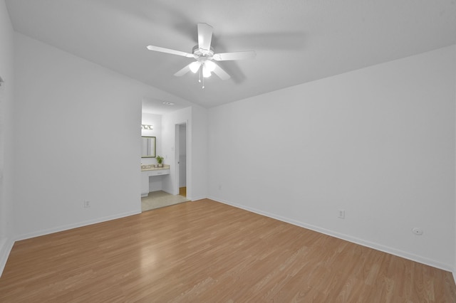 spare room with baseboards, ceiling fan, and light wood finished floors