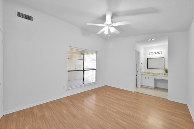 interior space featuring visible vents, baseboards, light wood-style flooring, and a ceiling fan