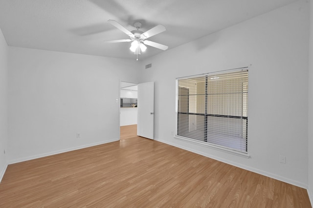 unfurnished room with baseboards, light wood-type flooring, ceiling fan, and vaulted ceiling