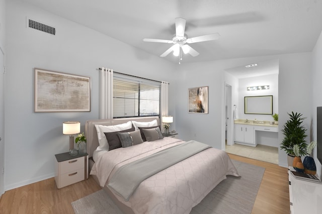 bedroom featuring baseboards, visible vents, ensuite bathroom, and light wood-type flooring