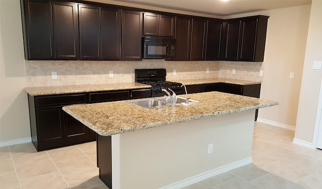 kitchen featuring black appliances, a sink, tasteful backsplash, light tile patterned flooring, and baseboards