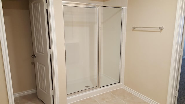 full bathroom with tile patterned floors, baseboards, and a stall shower