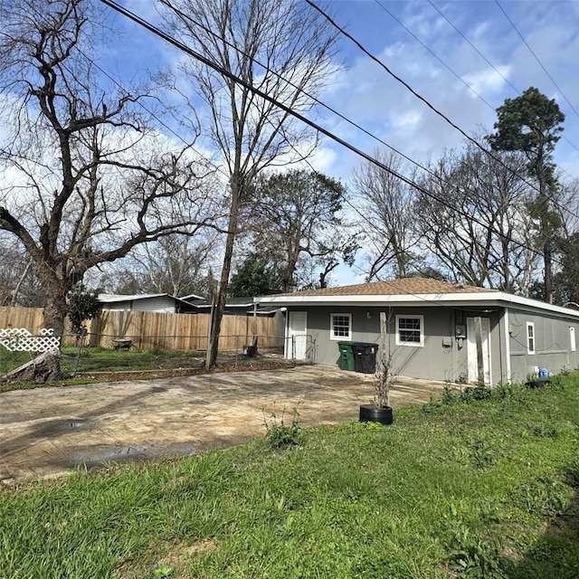 back of house featuring stucco siding and fence