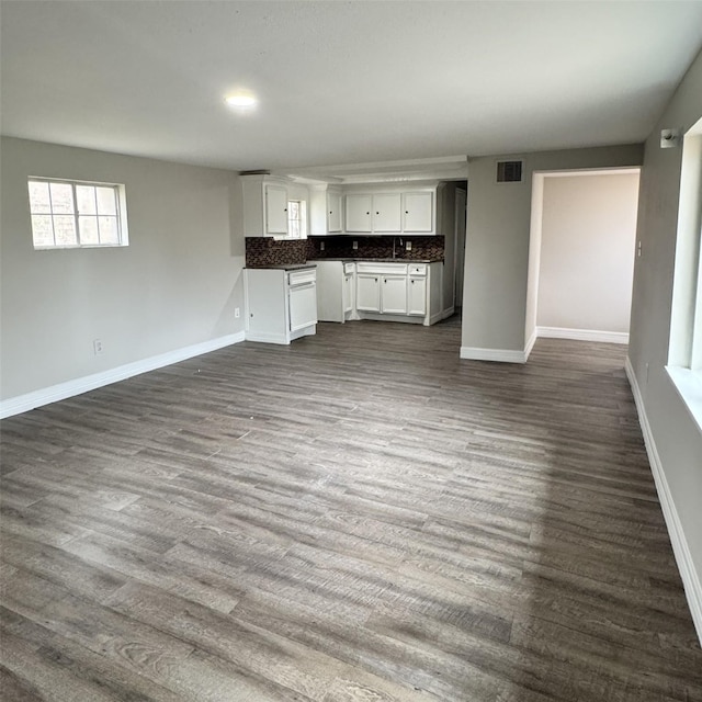 kitchen with visible vents, tasteful backsplash, dark countertops, open floor plan, and dark wood-style flooring