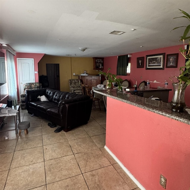 living area featuring light tile patterned flooring, visible vents, and plenty of natural light