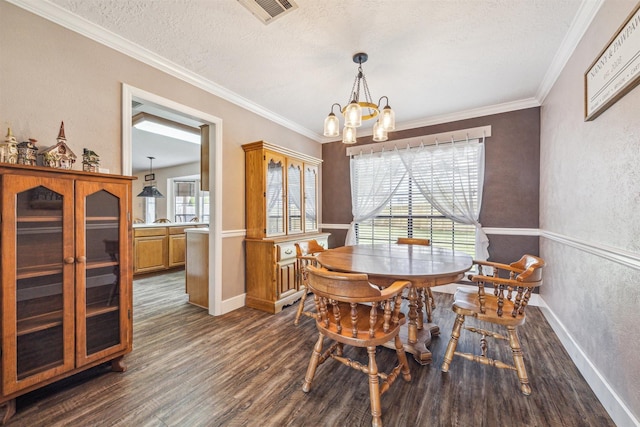 dining area featuring dark wood-style floors, visible vents, an inviting chandelier, ornamental molding, and a textured ceiling