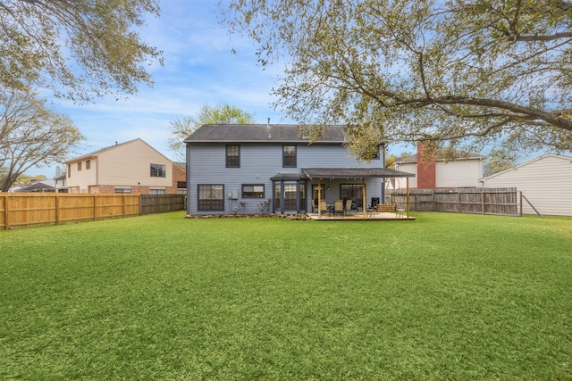 rear view of house with a fenced backyard, a patio, and a yard