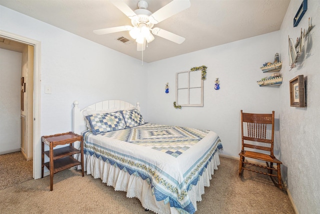 bedroom with ceiling fan, visible vents, and light carpet