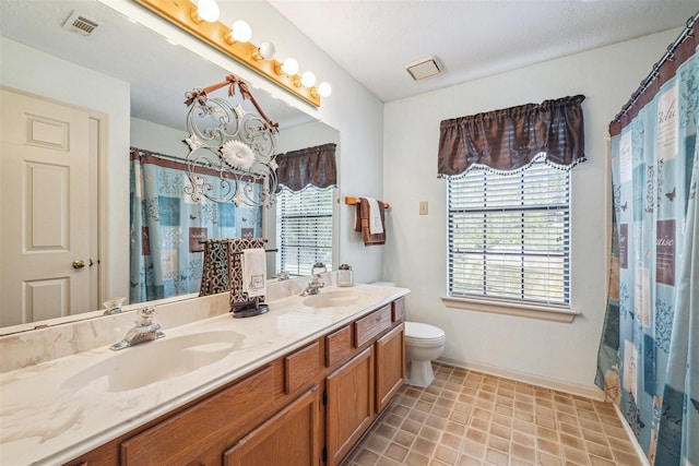 full bathroom featuring plenty of natural light, toilet, visible vents, and a sink