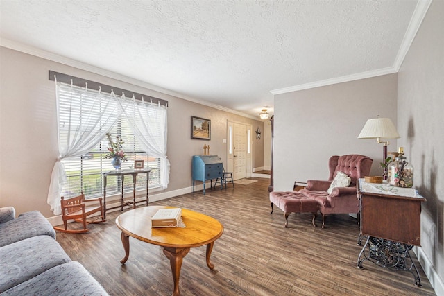 living room featuring ornamental molding, a textured ceiling, baseboards, and wood finished floors