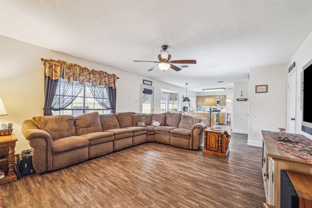 living room with visible vents, a ceiling fan, dark wood-style flooring, and baseboards