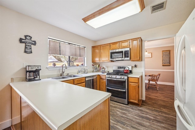 kitchen featuring visible vents, a sink, appliances with stainless steel finishes, a peninsula, and light countertops