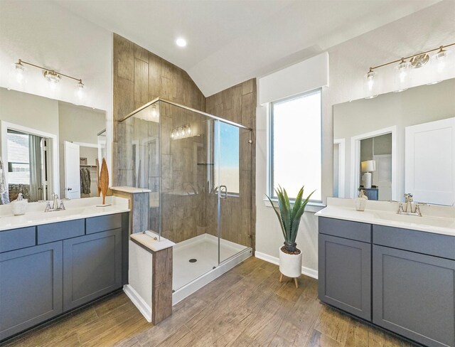 bathroom featuring a sink, a shower stall, lofted ceiling, and a healthy amount of sunlight