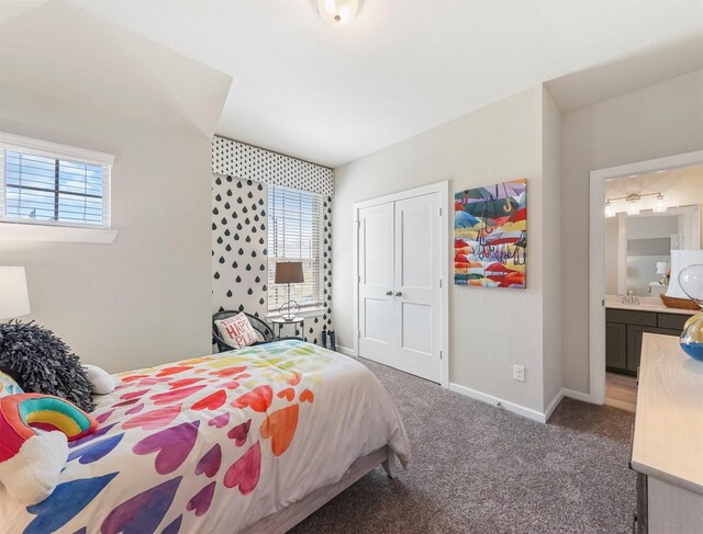 carpeted bedroom with baseboards, a closet, and a sink