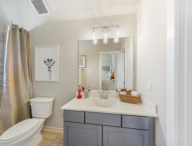 bathroom with toilet, visible vents, and vanity