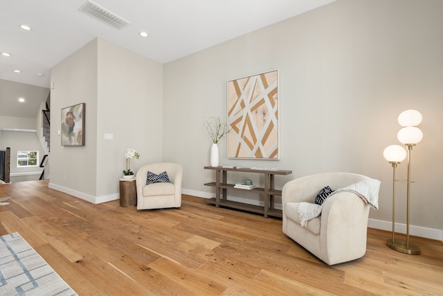 sitting room featuring hardwood / wood-style floors, baseboards, visible vents, recessed lighting, and stairs