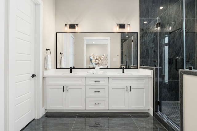 full bathroom featuring double vanity, marble finish floor, a stall shower, and a sink