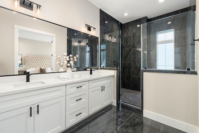 ensuite bathroom featuring double vanity, a shower stall, marble finish floor, and a sink