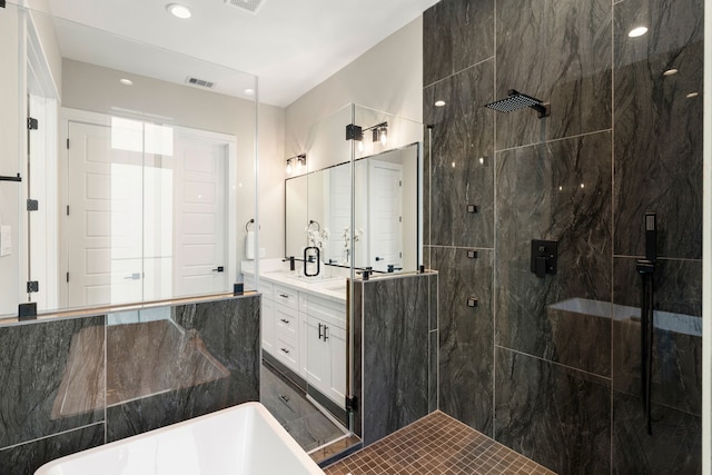 bathroom featuring vanity, a shower stall, a soaking tub, and visible vents