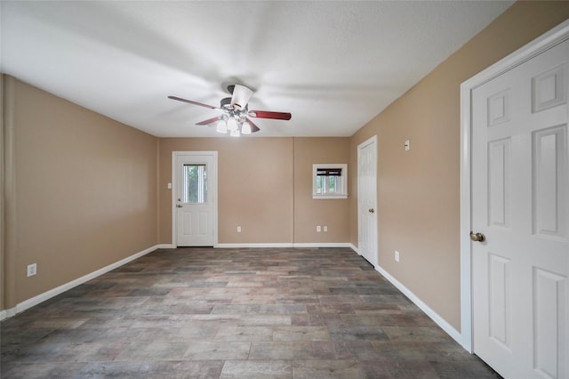 unfurnished room featuring a wealth of natural light, a ceiling fan, and baseboards