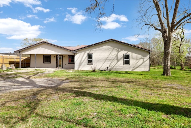 back of property with a lawn, fence, and crawl space