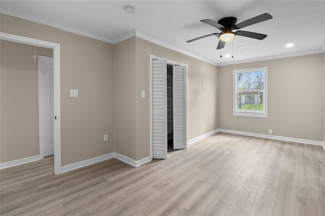 unfurnished bedroom with baseboards, light wood-style flooring, and crown molding