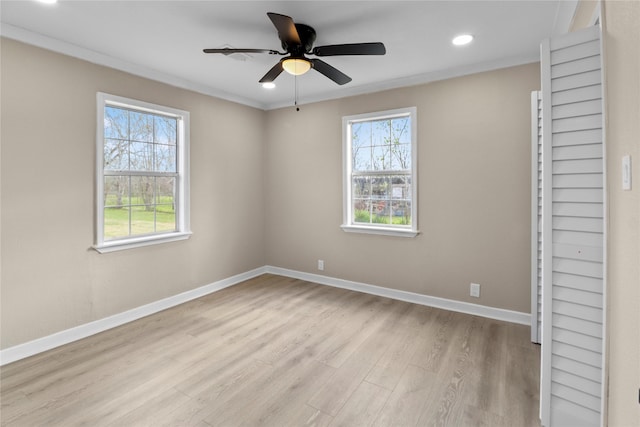 empty room featuring a ceiling fan, baseboards, light wood finished floors, recessed lighting, and crown molding