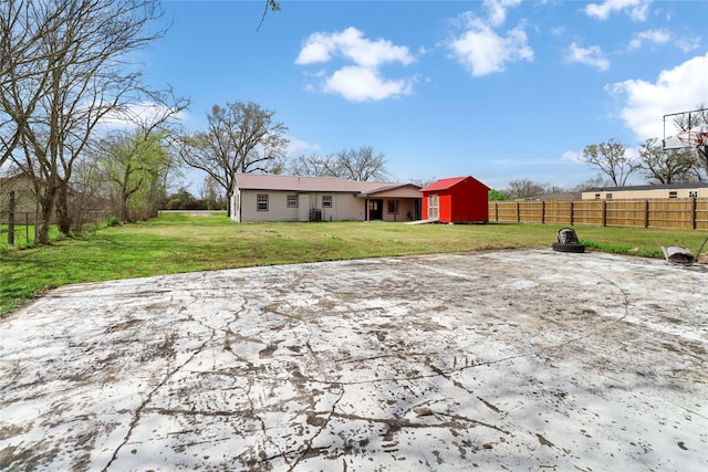 back of property with a lawn and fence