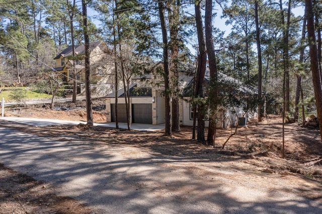 view of front of home featuring a garage and dirt driveway