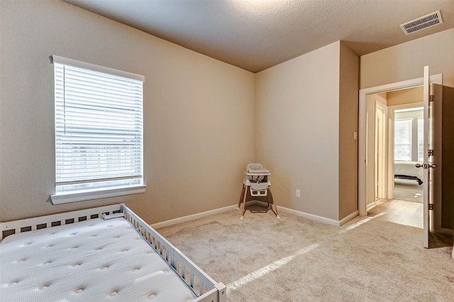 unfurnished bedroom featuring visible vents, baseboards, and carpet flooring