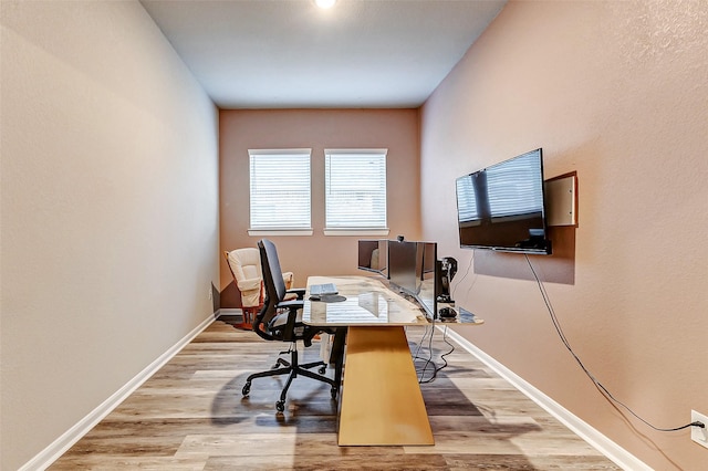 office space with baseboards and light wood finished floors