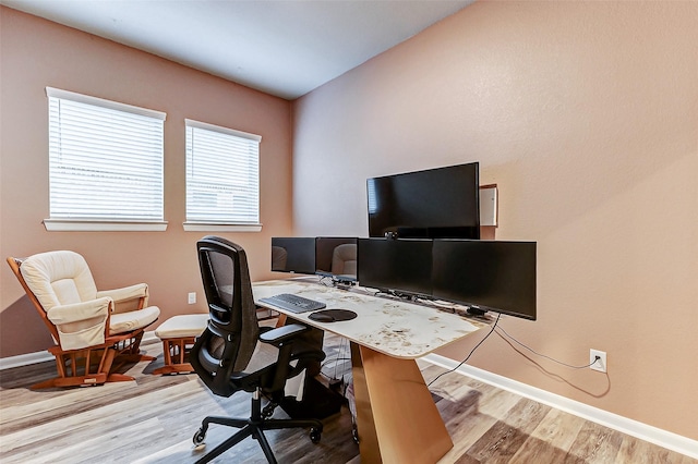 home office with baseboards and wood finished floors