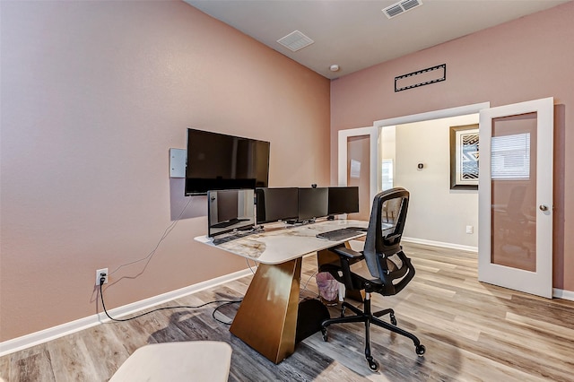 home office with visible vents, baseboards, and light wood-style floors