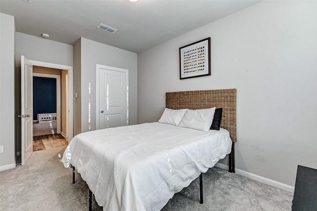 bedroom with light colored carpet, visible vents, and baseboards