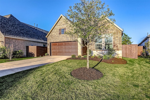 view of front of house featuring brick siding, driveway, and fence