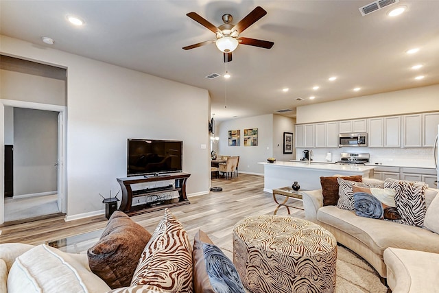 living room featuring recessed lighting, visible vents, and light wood-style floors