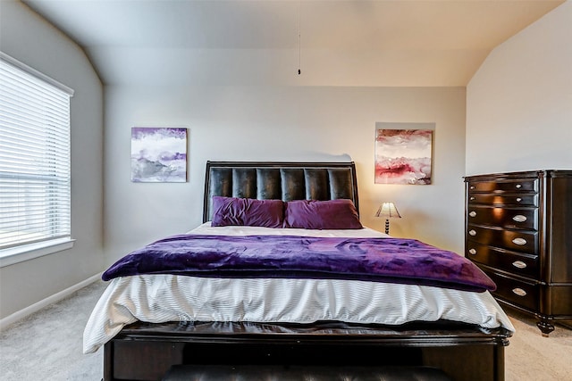 bedroom with light colored carpet, baseboards, and lofted ceiling