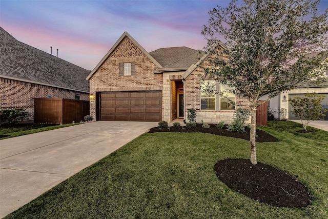 view of front facade featuring brick siding, concrete driveway, a front yard, a garage, and stone siding