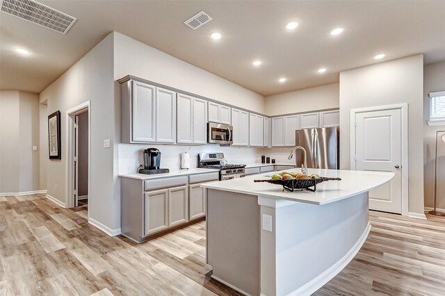 kitchen featuring visible vents, stainless steel appliances, light countertops, and a sink