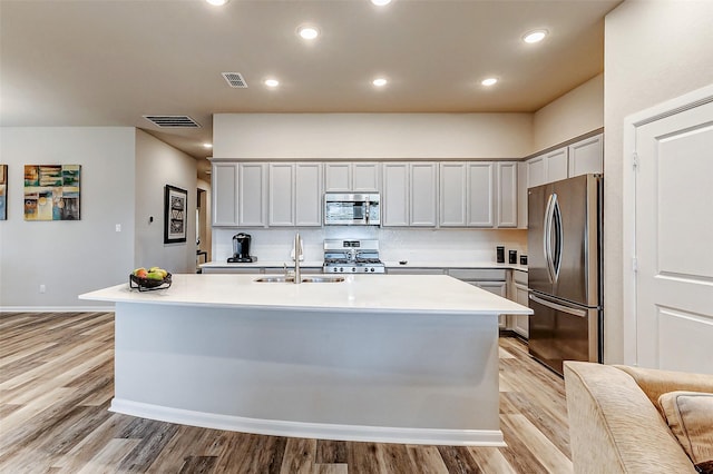 kitchen featuring a sink, stainless steel appliances, visible vents, and light countertops