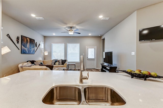 kitchen with a sink, visible vents, open floor plan, and light countertops