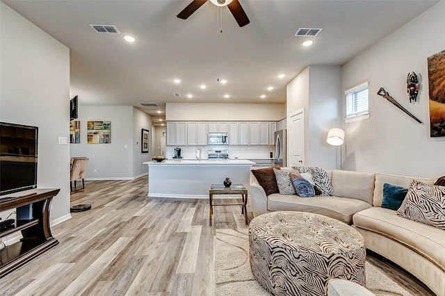 living area featuring recessed lighting, visible vents, and light wood finished floors