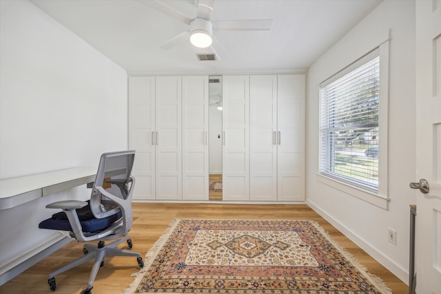 office space with a ceiling fan, light wood-style flooring, baseboards, and visible vents