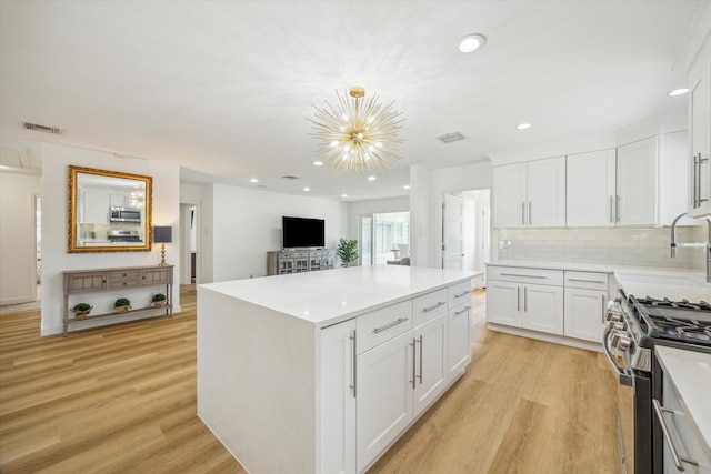 kitchen featuring light wood-style flooring, a center island, visible vents, and stainless steel appliances