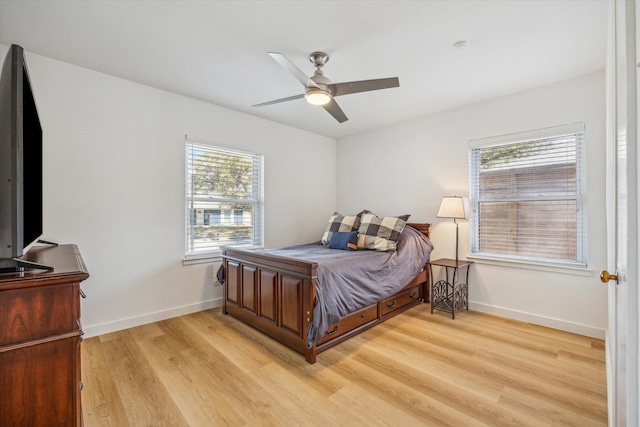 bedroom with a ceiling fan, light wood-type flooring, and baseboards