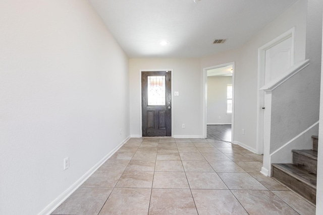 entryway with light tile patterned flooring, visible vents, stairway, and baseboards