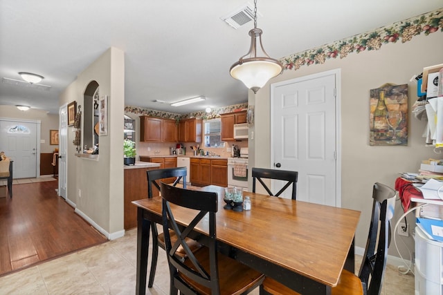 dining area featuring light tile patterned floors, visible vents, and baseboards