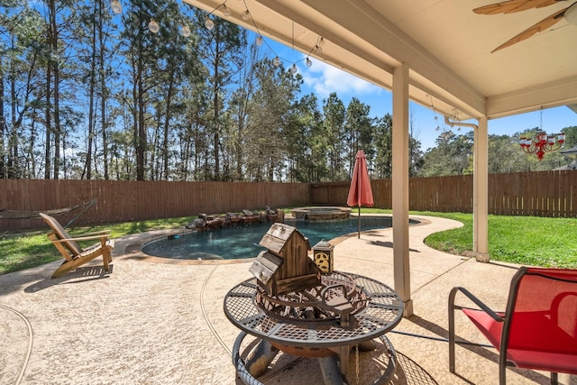 view of patio / terrace with a fenced in pool, an in ground hot tub, a ceiling fan, and a fenced backyard